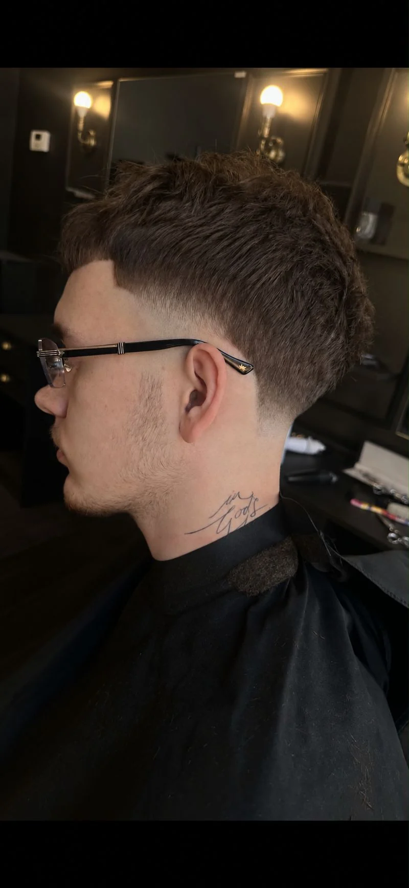 Profil fryzury z wyraźną linią fade przy uchu